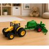 Niños jugando con el tractor agrícola en el jardín