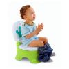 Niño o niña sentado en el orinal interactivo verde con corona azul durante el aprendizaje