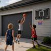 Niños disfrutando de un juego de baloncesto con el tablero colgante.