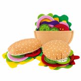 Niña jugando con el set de hamburguesa en su cocina de juguete