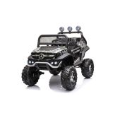 Niño conduciendo el Mercedes Unimog S camuflaje en jardín con mando parental
