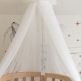 Uso del dosel de tul en una cuna, creando un ambiente acogedor para el bebé.